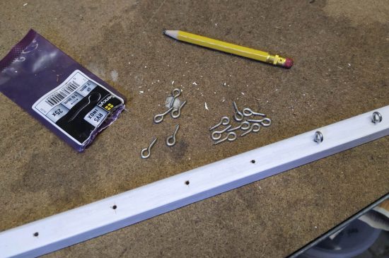 screwing eyelets in the slab of wood