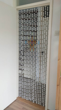 Gedurende vele (vele) jaren spaarde ik lege garenklosjes, waarvan ik uiteindelijk een decoratief gordijn maakte voor de ingang van mijn hobbykamer. Gordijn van lege garenklosjes