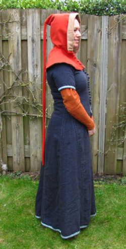 Middeleeuwse cotehardie van wol naar een model van rond 1450, gedragen over een wollen kirtle. Wollen kaproen met knoopjes. Alles, van naad tot knoopje, is met de hand genaaid. Middeleeuwse cotehardie en kaproen
