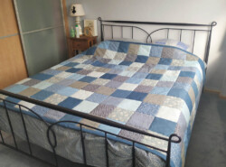 Quilt gemaakt met vierkantjes van zelf gecombineerde stofjes Lapjesquilt